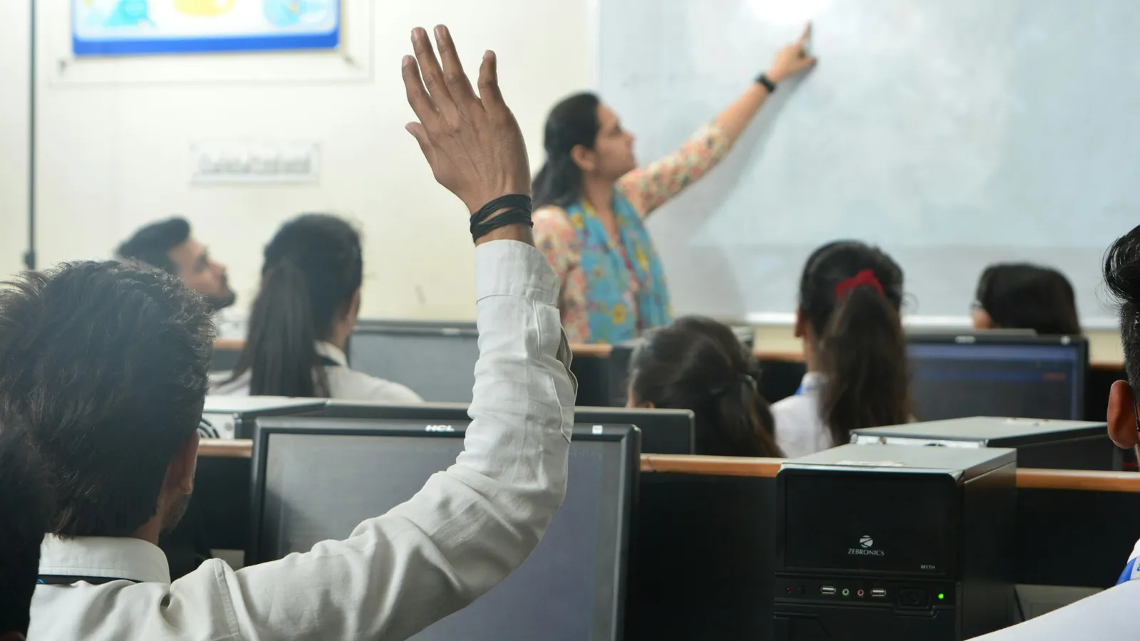 Student raising a hand to ask a question in class