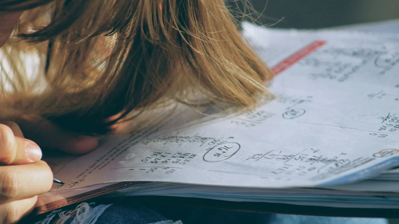 Student resting her head on a test paper