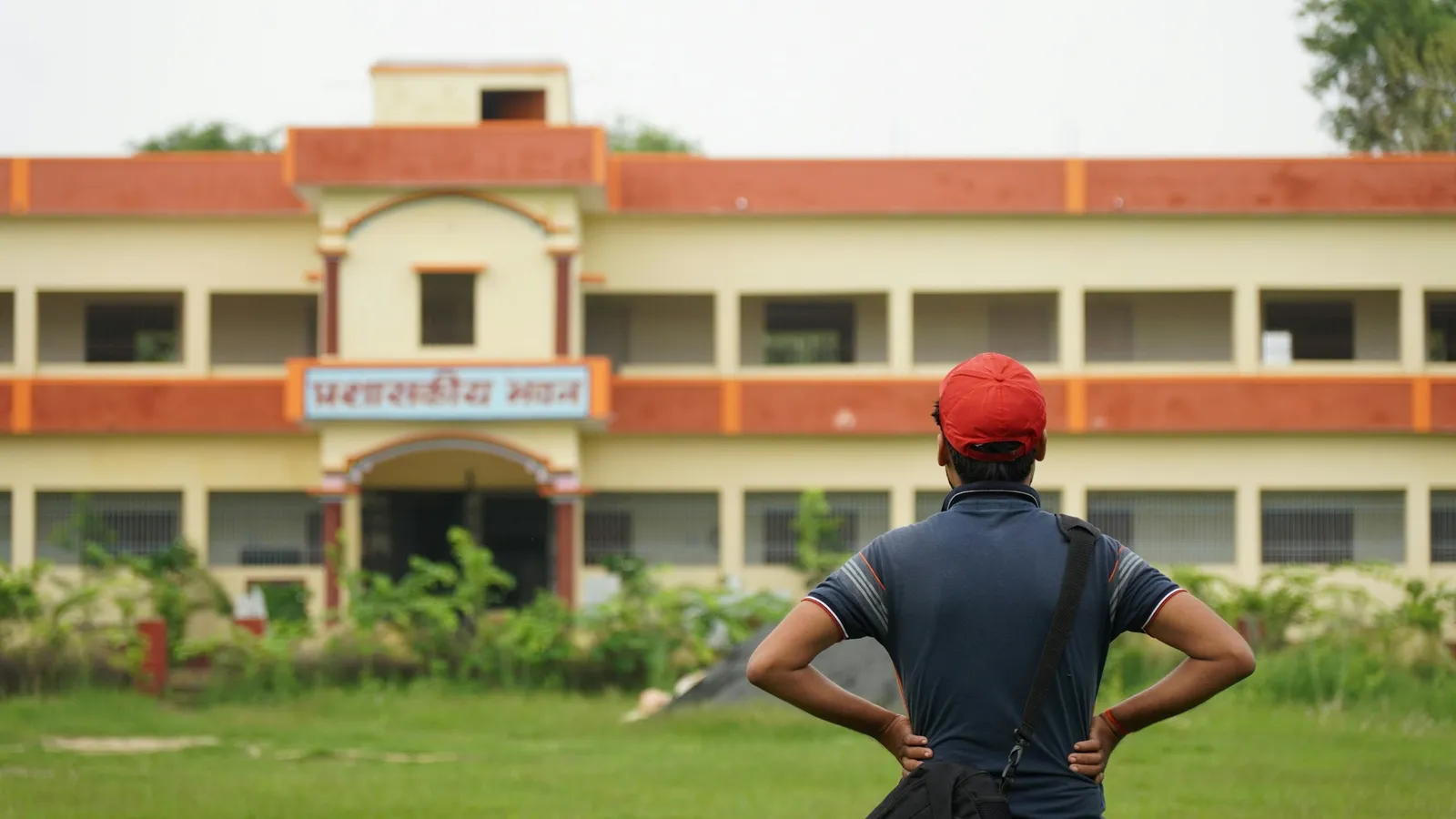 Student standing in front of a school building