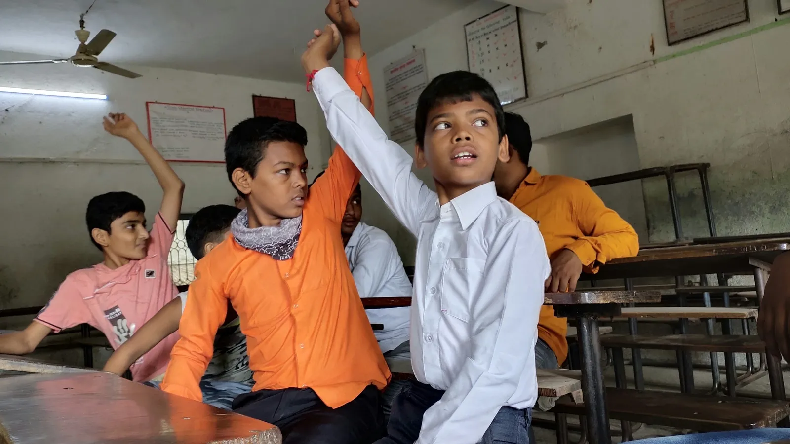Students raising their hands in a classroom