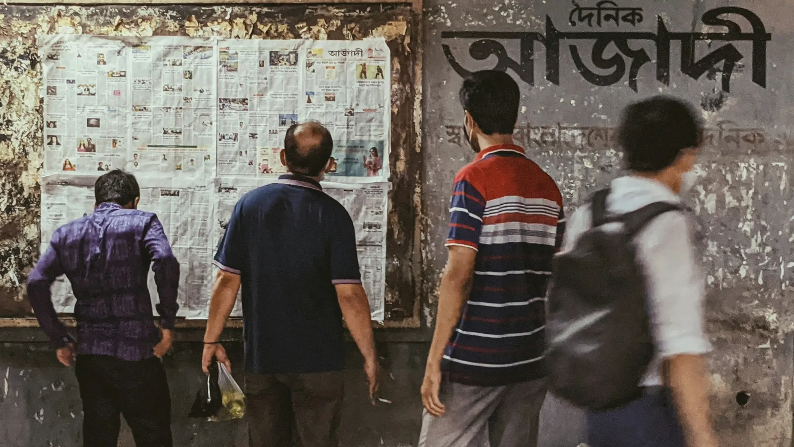 Students reading notices pinned on a wall