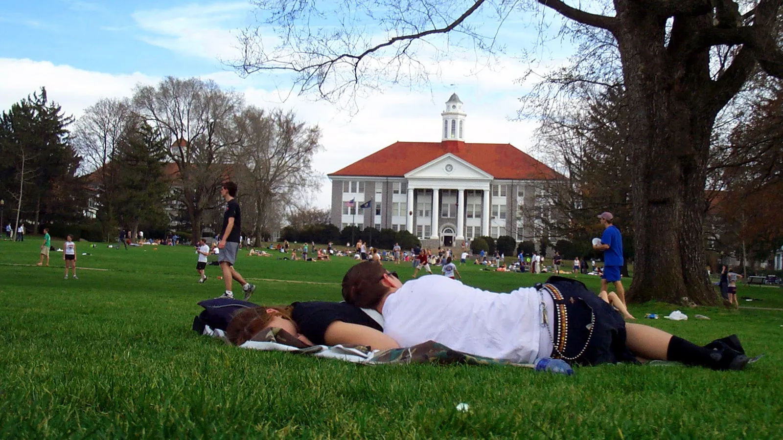 Students relaxing on the grass on a university campus quad