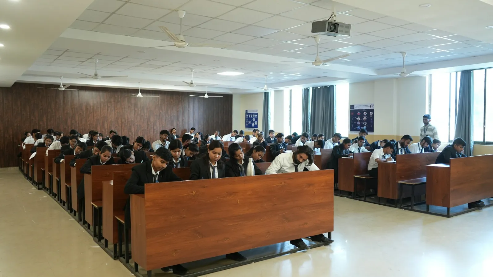 Students seated in rows in a large exam hall