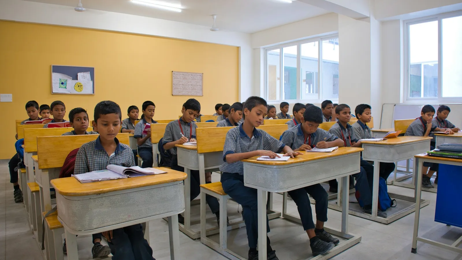 Students sitting in rows of desks in a bright classroom