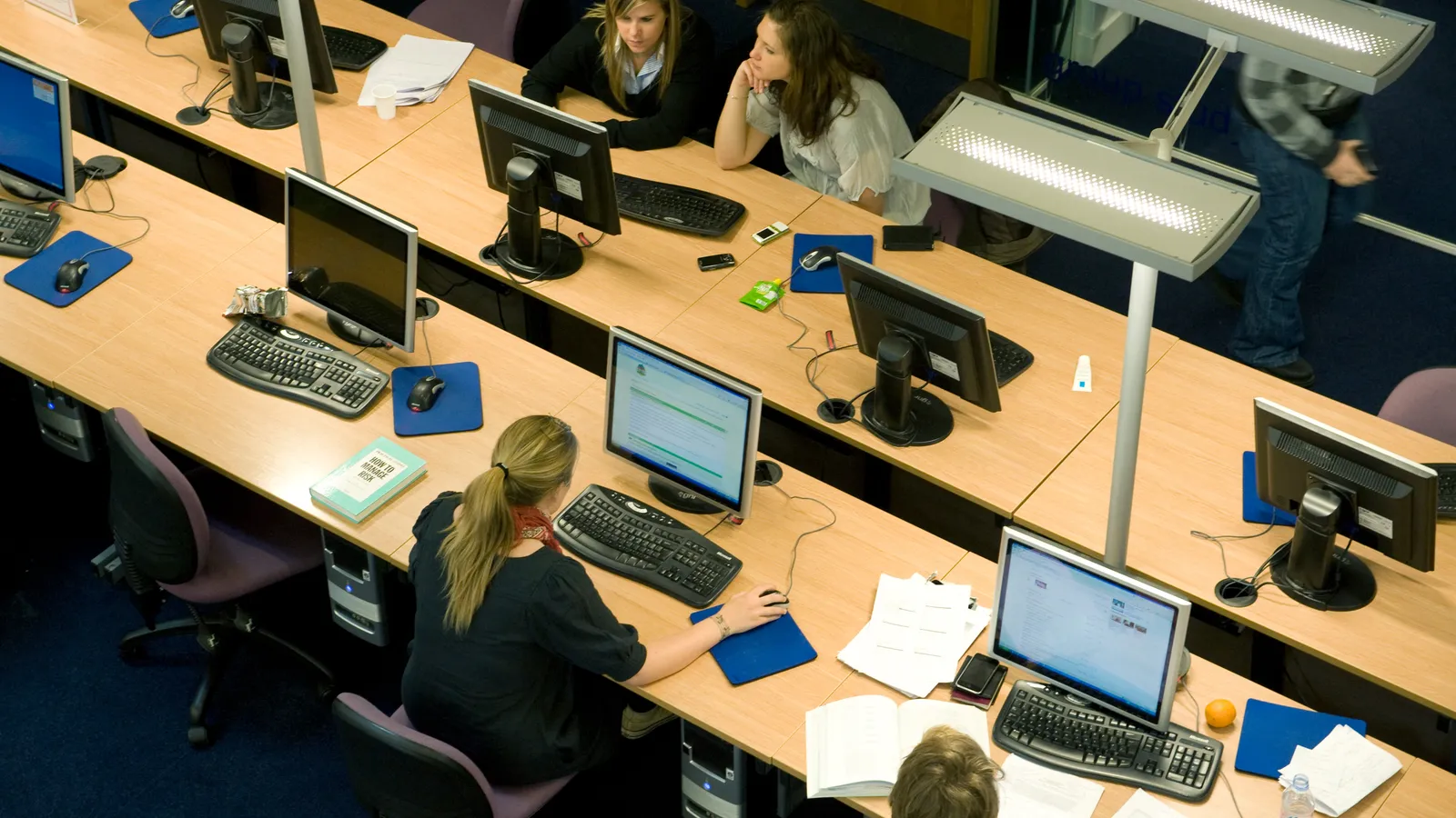 Students working at rows of computers in a university library