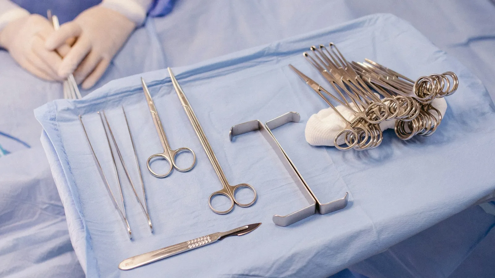 Surgical instruments laid out on a blue sterile cloth