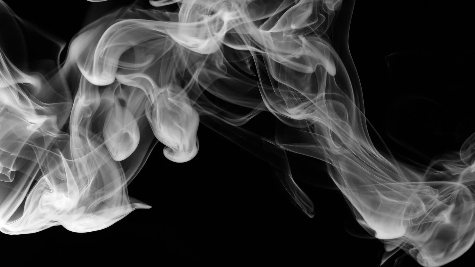 Swirling white smoke on a black background