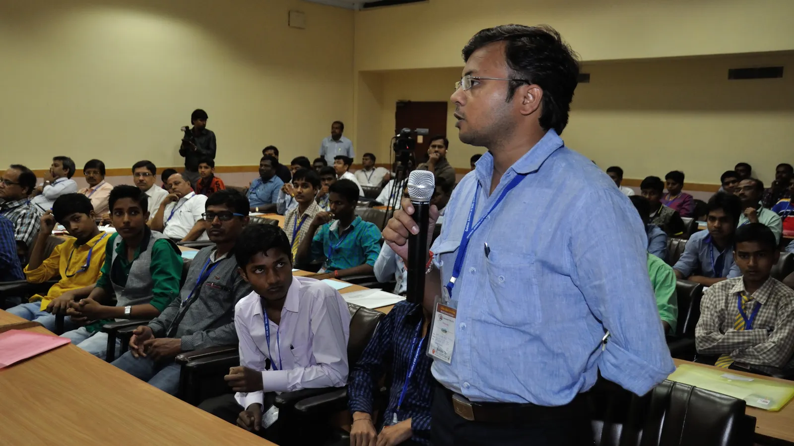 Teacher with a microphone speaks to school students at a science workshop in Kolkata