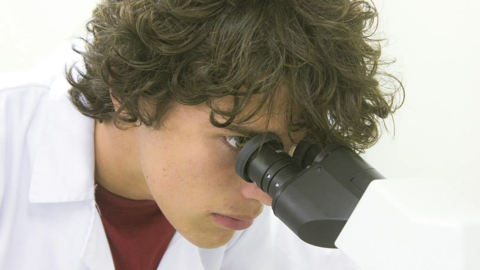 Teenager looking through a microscope