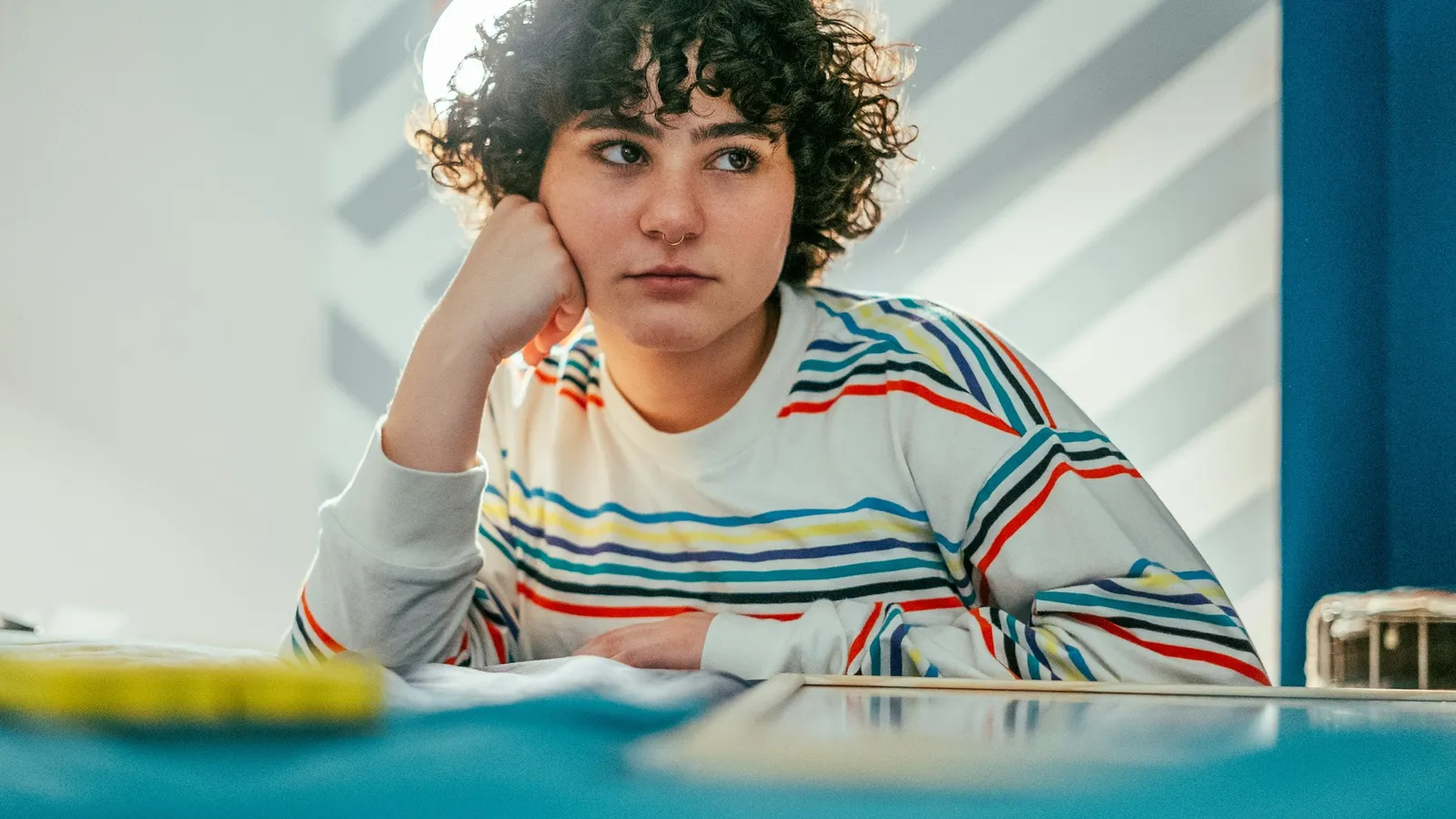 Teenager resting her chin on her hand at a desk