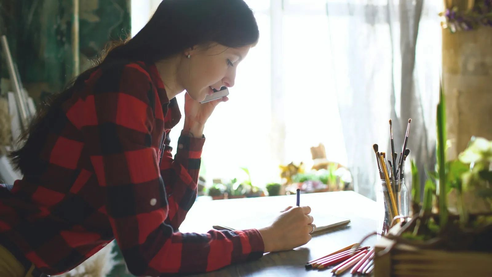 Teenager studying at a desk by a window