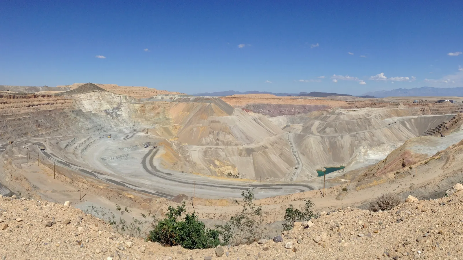 Terraced benches and haul roads curving through a large open-pit copper mine in Arizona