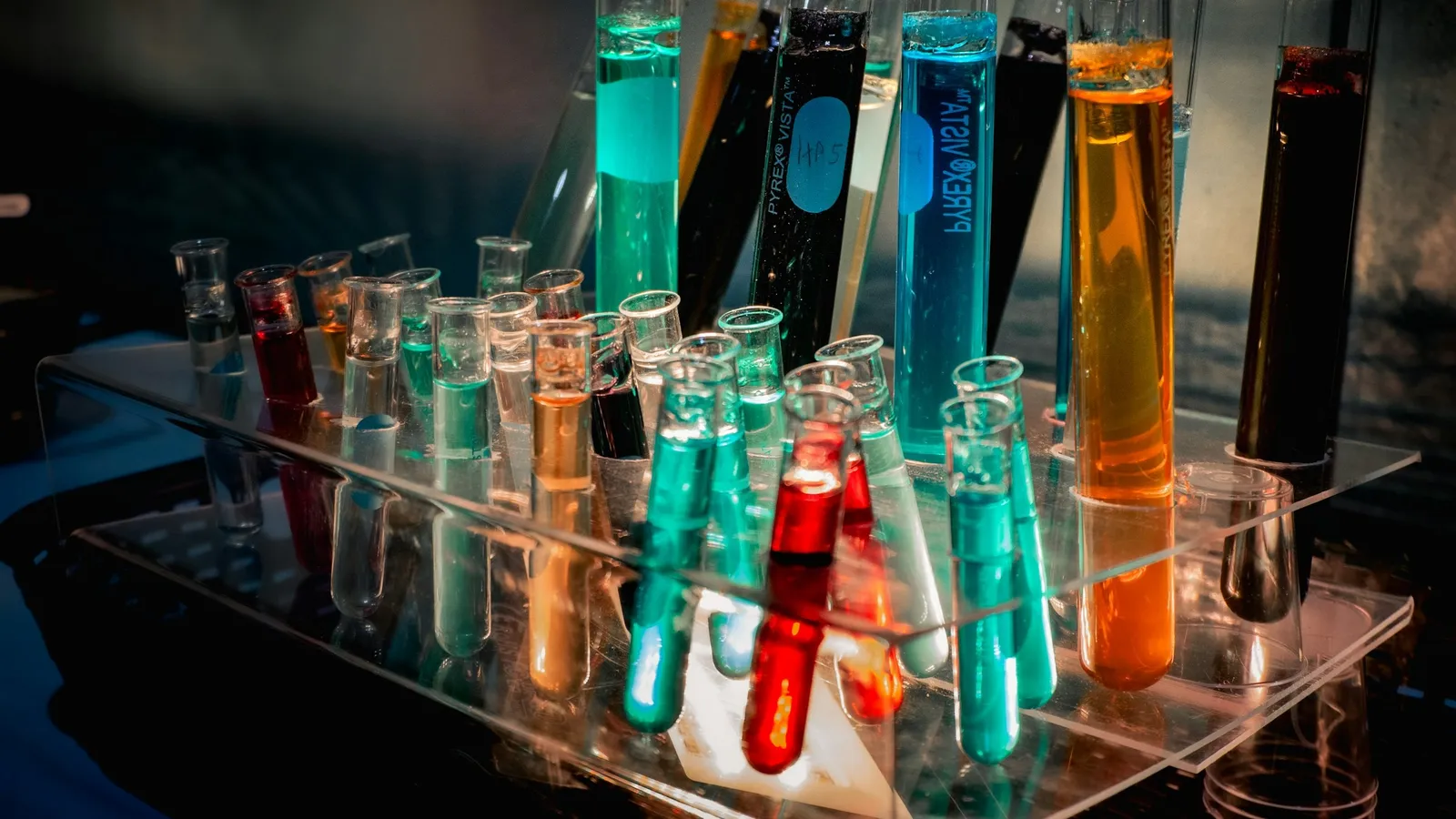 Test tubes of brightly coloured liquids standing in a clear rack