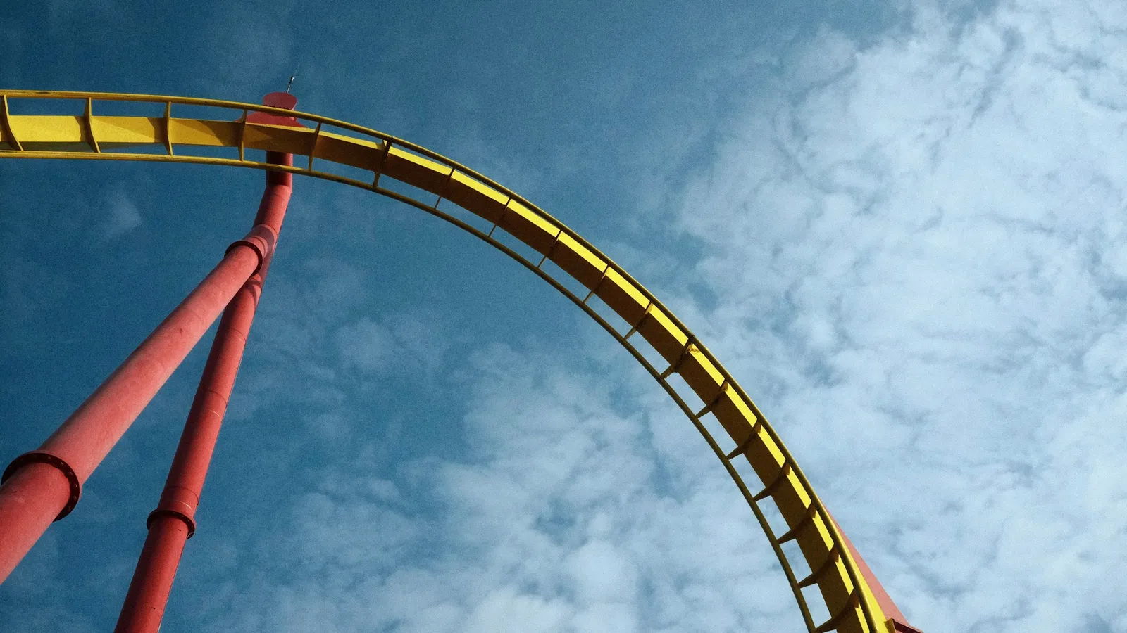 The curving track of a roller coaster against the sky