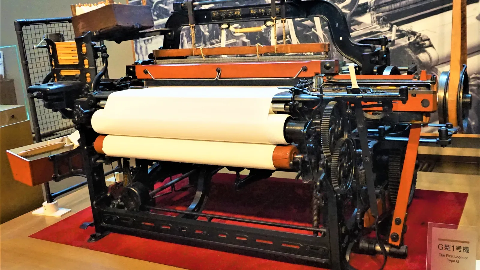 The first Toyoda Type G automatic loom on display in a museum, with white cloth rolls