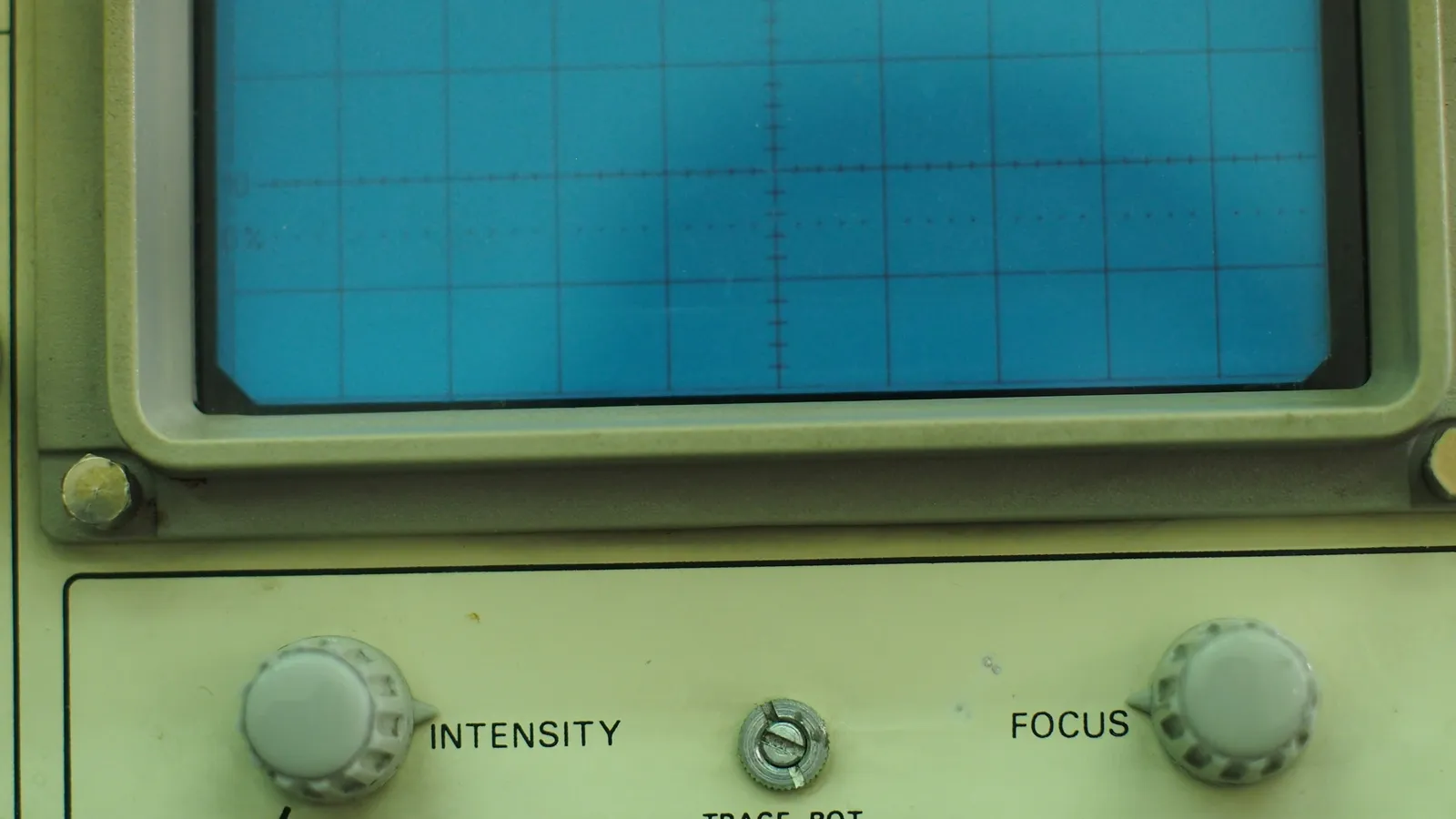 The green screen of an old oscilloscope