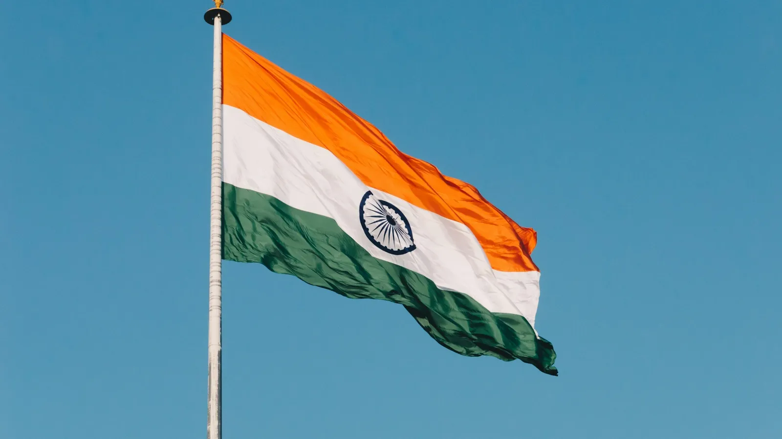 The Indian flag flying against a blue sky