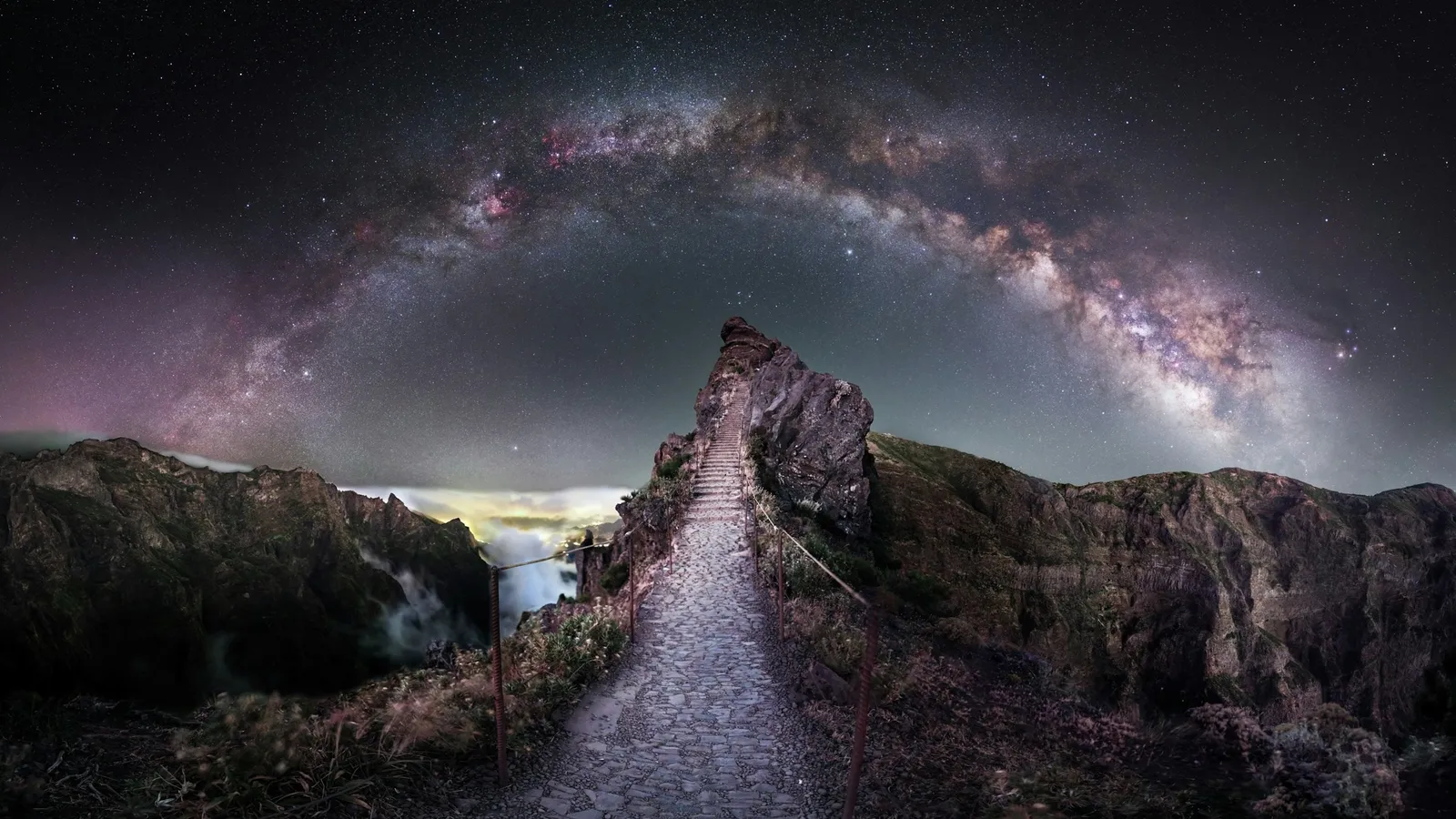 The Milky Way arching over a path at night