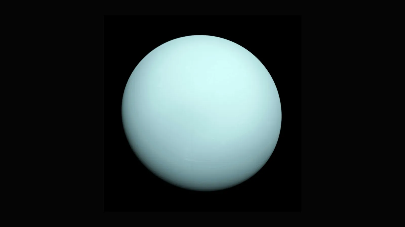 The pale blue-green disc of the planet Uranus against black