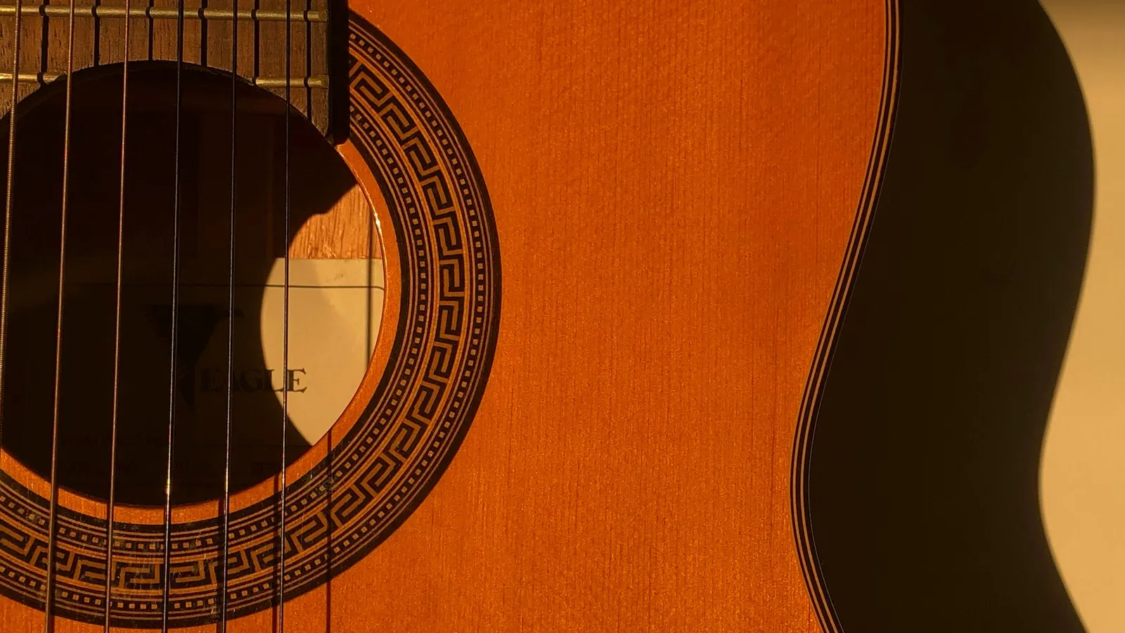 The strings and sound hole of an acoustic guitar