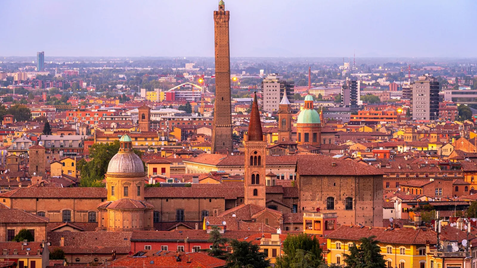 The towers and red rooftops of Bologna at dusk