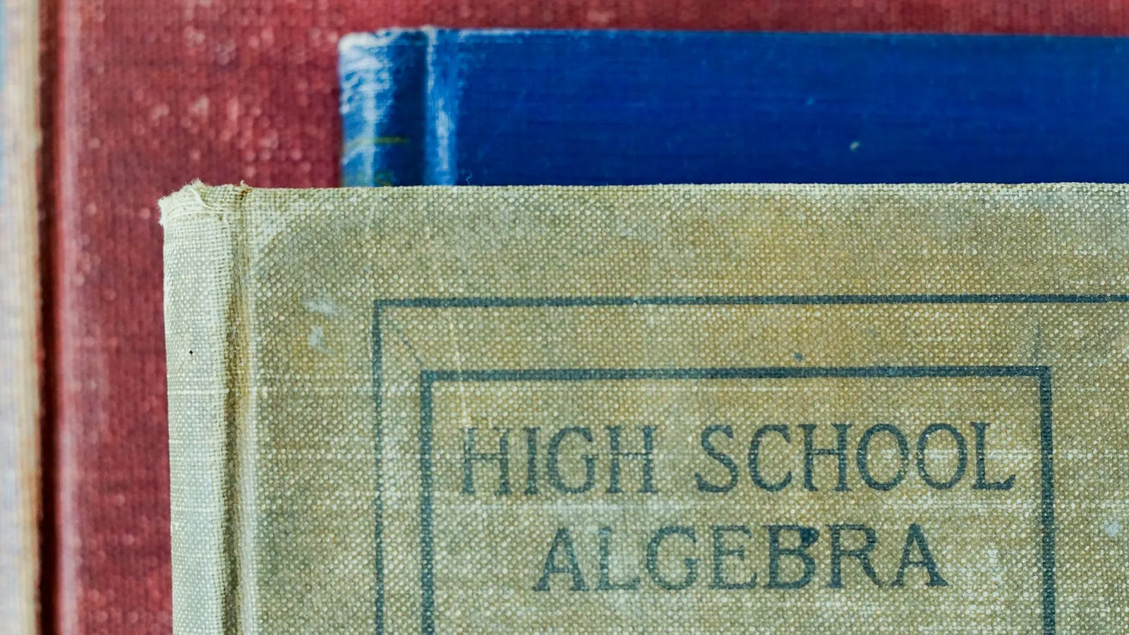 The worn cloth cover of an old high school algebra book
