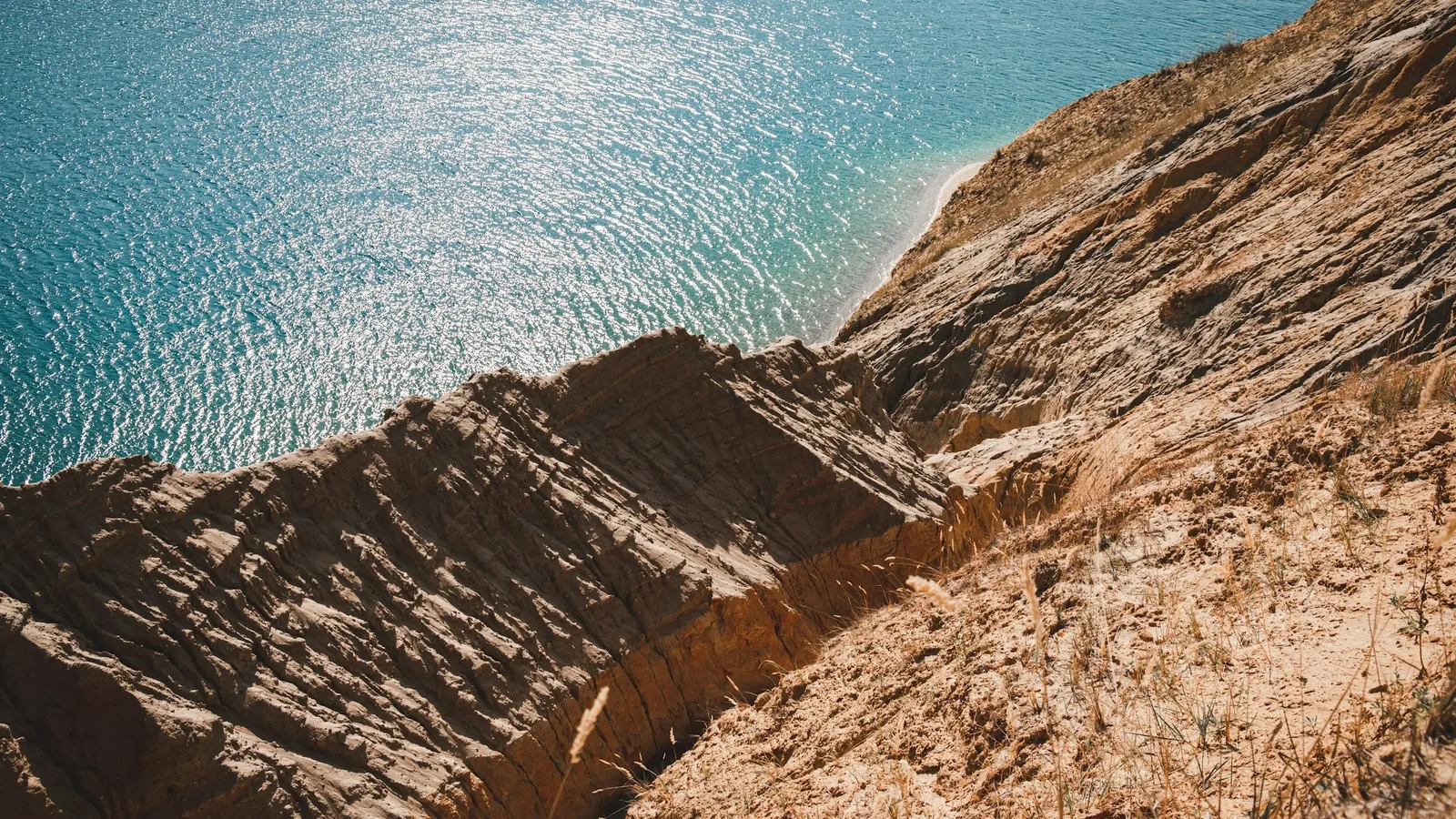 Tilted layers of rock running into the sea