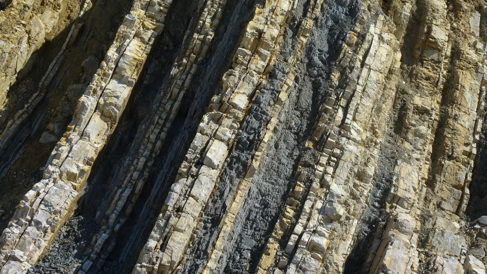 Tilted layers of sedimentary rock on a coastline