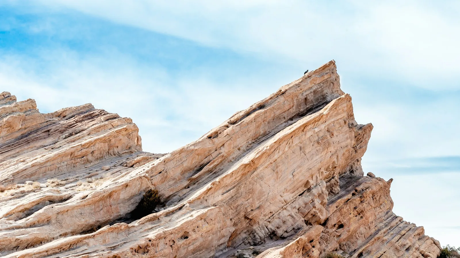 Tilted layers of sedimentary rock under a blue sky