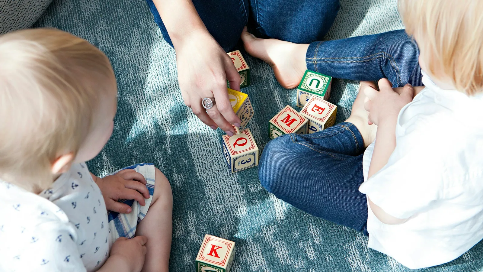 Toddler and adult playing with blocks on the floor
