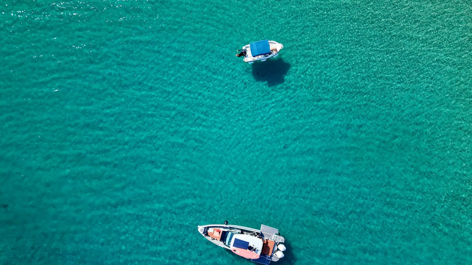 Two boats on turquoise water seen from above