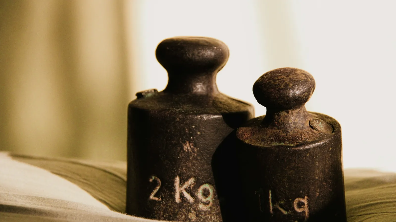 Two old iron weights marked in kilograms