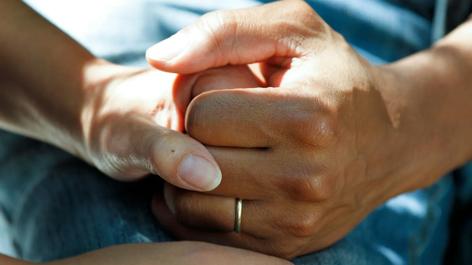 Two people holding hands in support
