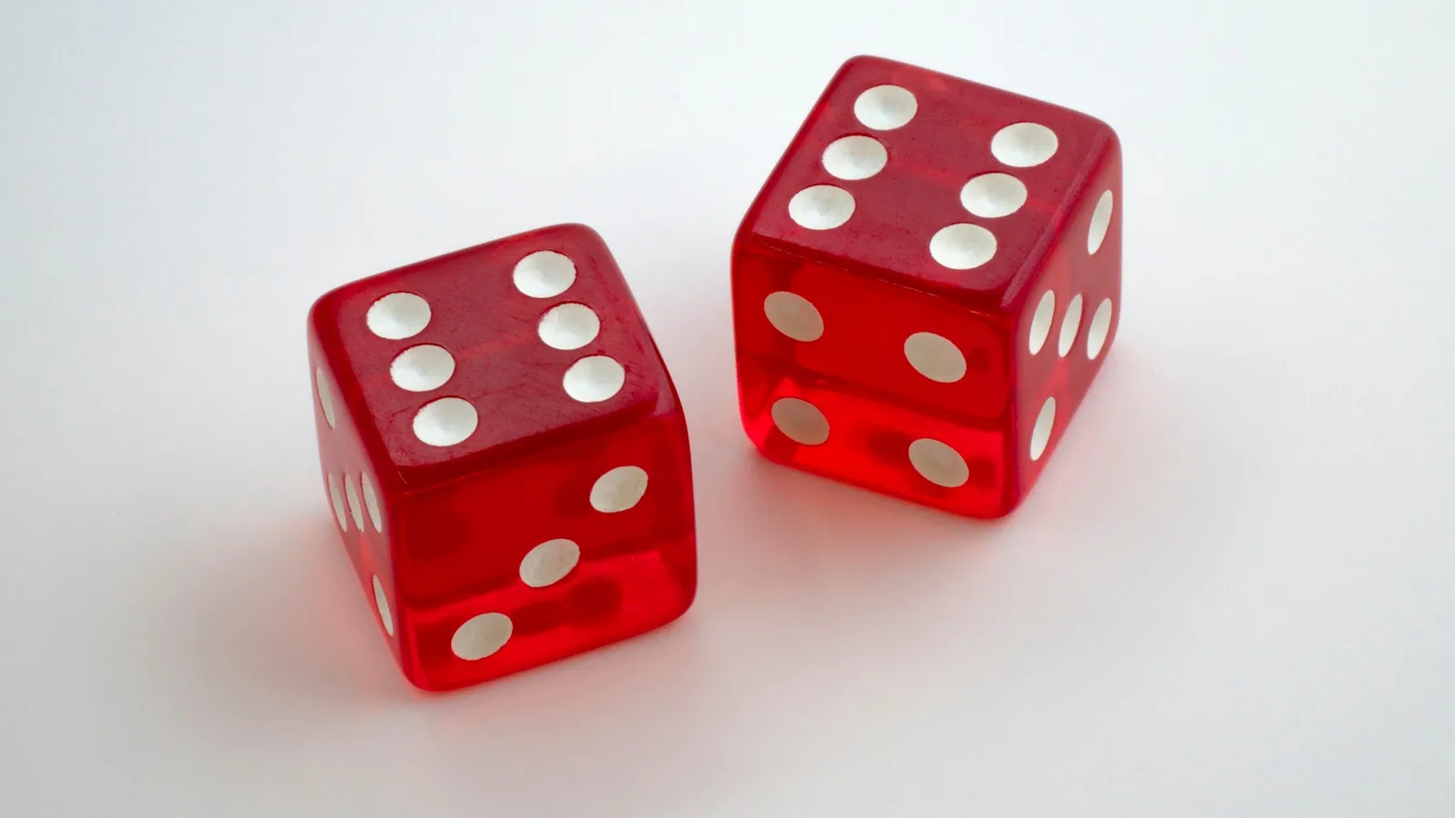 Two red dice on a white surface
