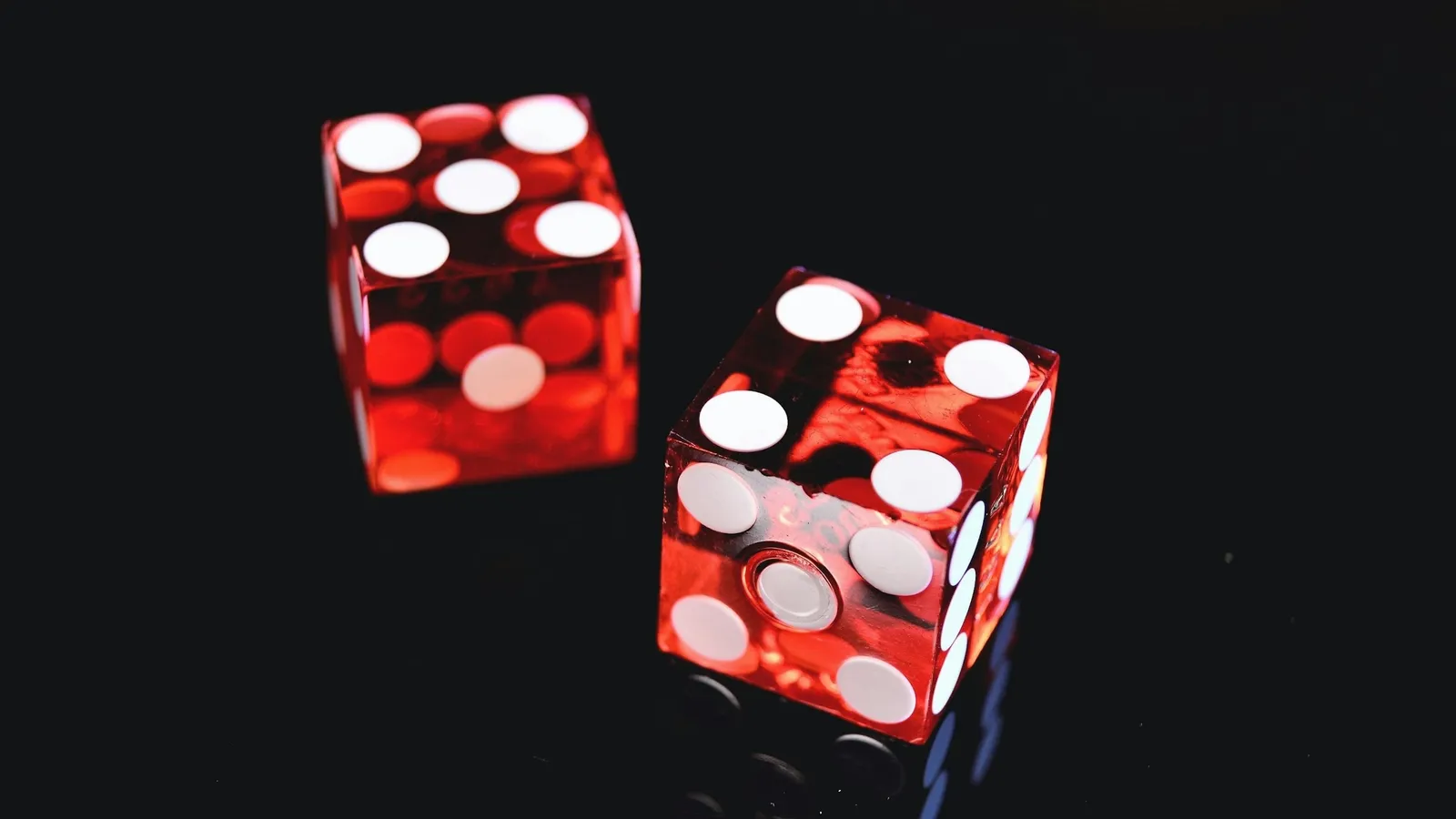 Two red translucent dice on a black background