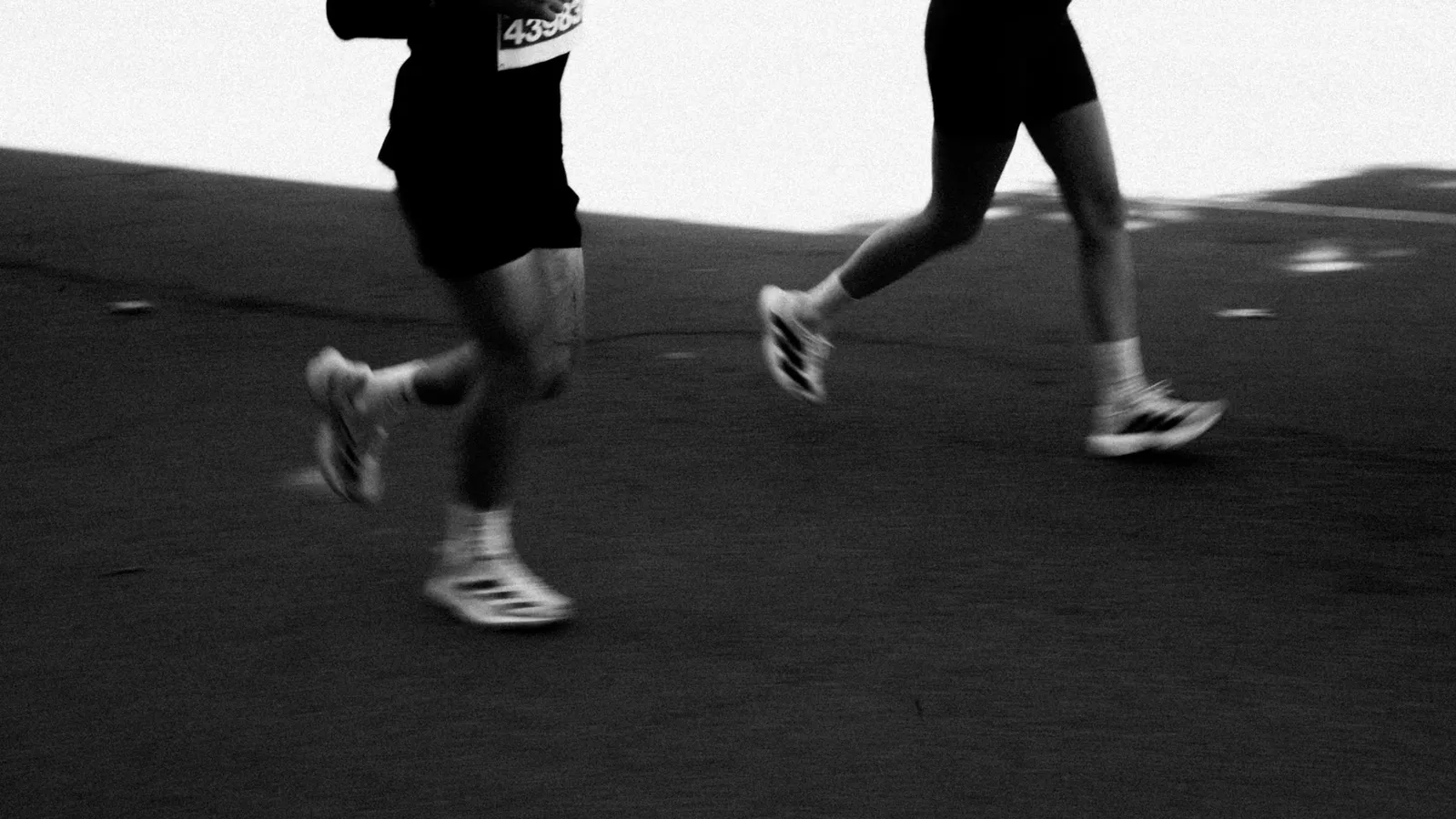 Two runners side by side, in black and white