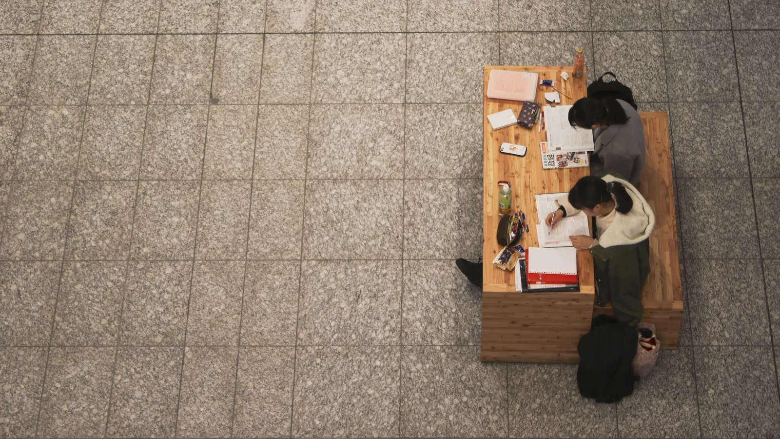 Two students studying at a desk from above