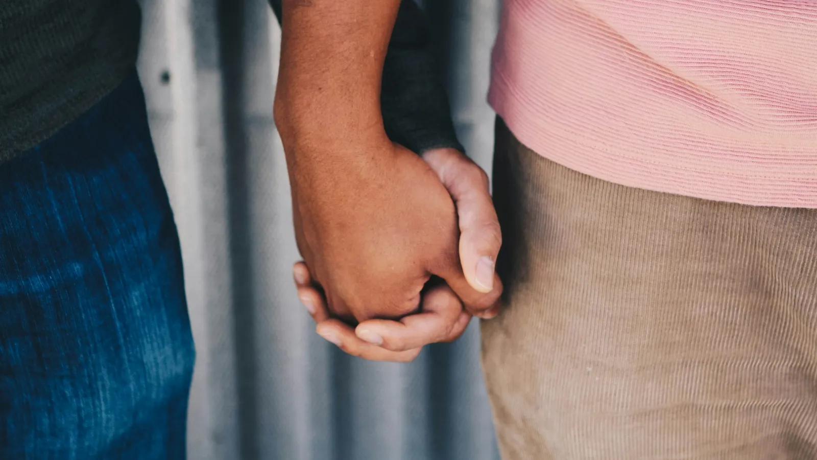 Two young people holding hands, seen close up