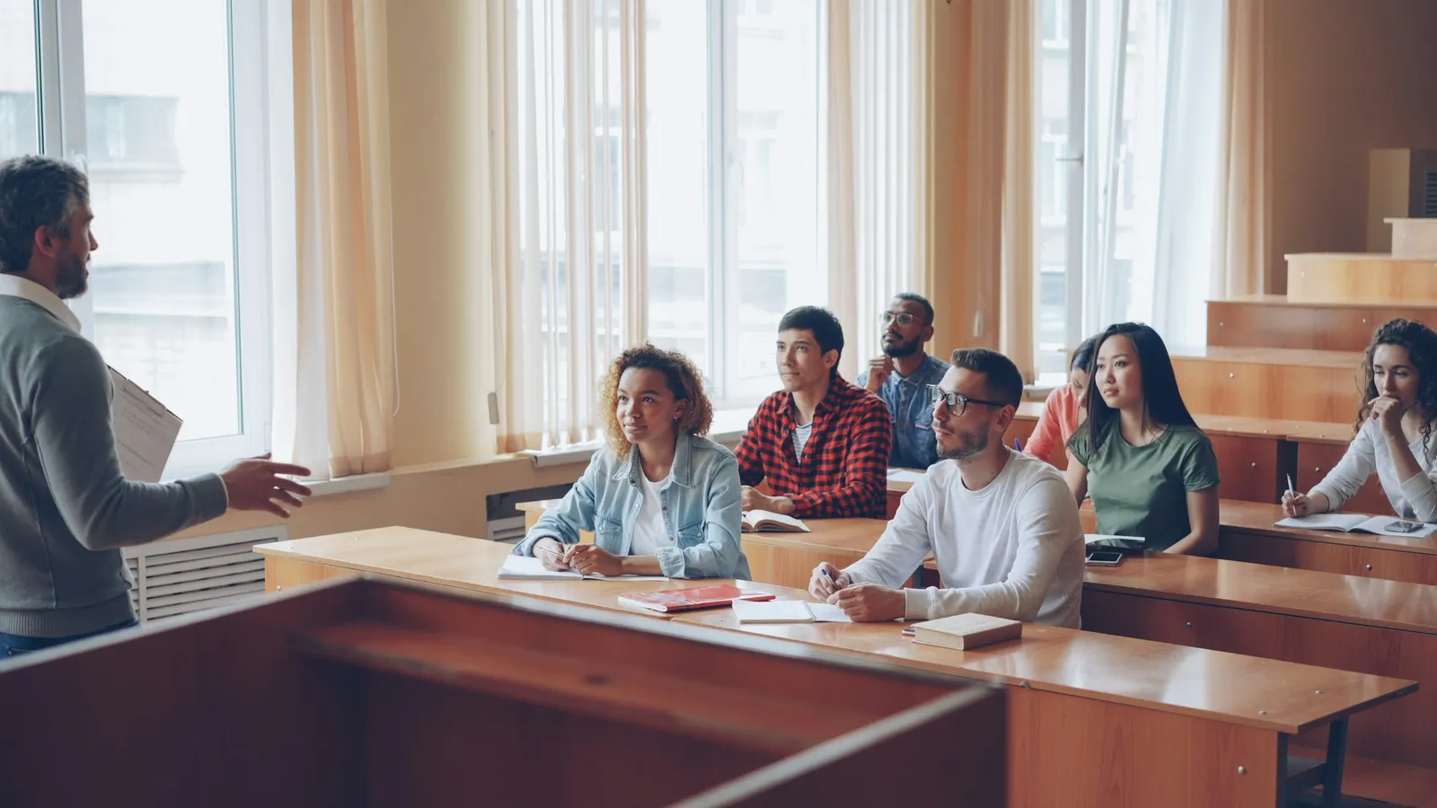 University students talking together in a tiered classroom