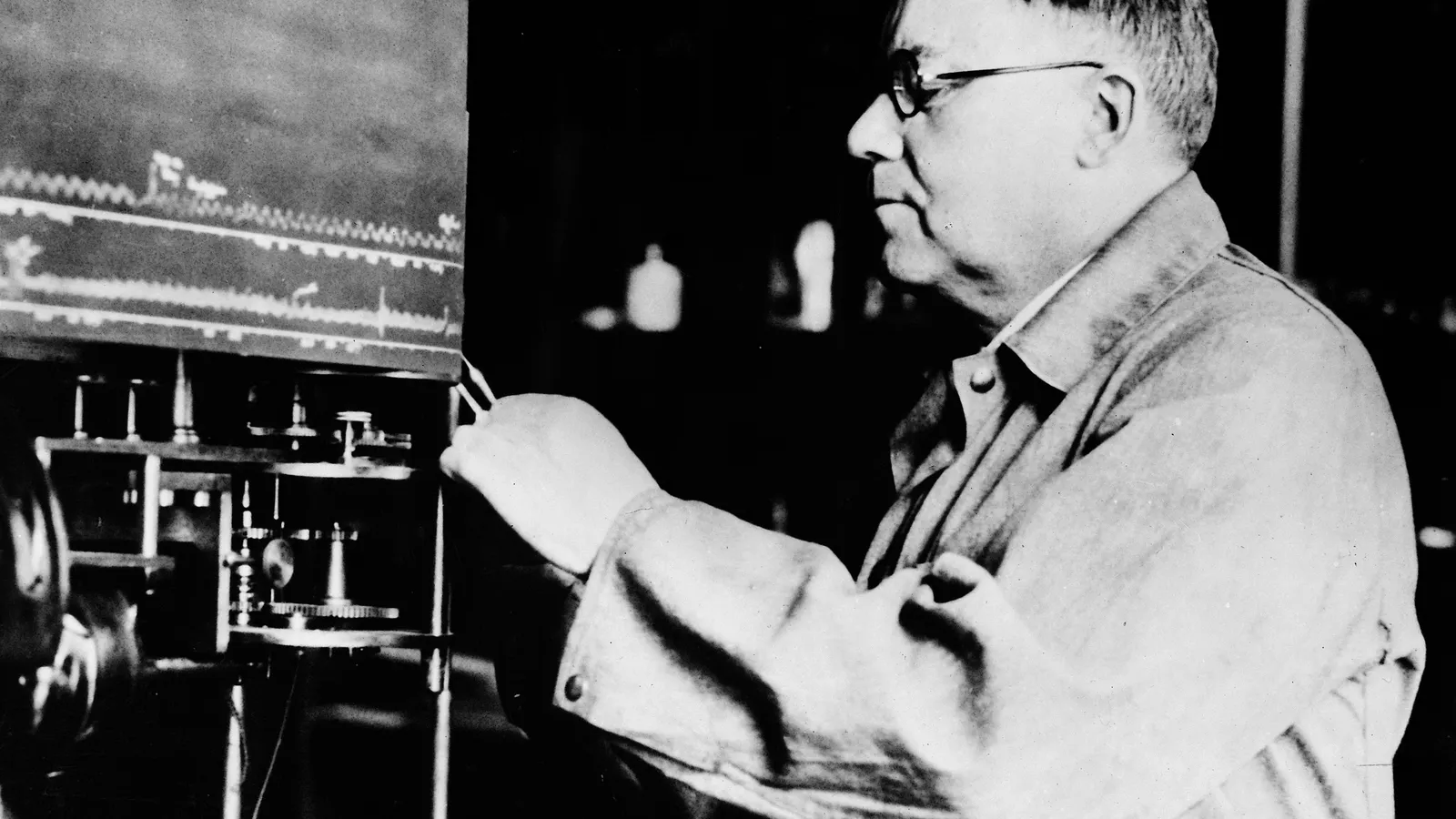 Walter Cannon in a work coat at a laboratory recording apparatus with traced lines