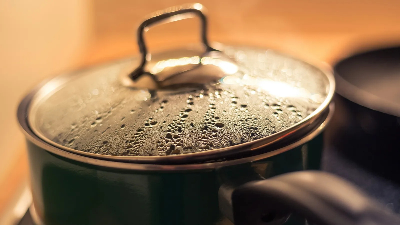 Water droplets condensed on the glass lid of a cooking pot