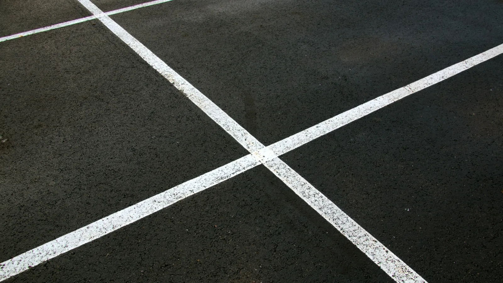 White lines crossing on dark tarmac