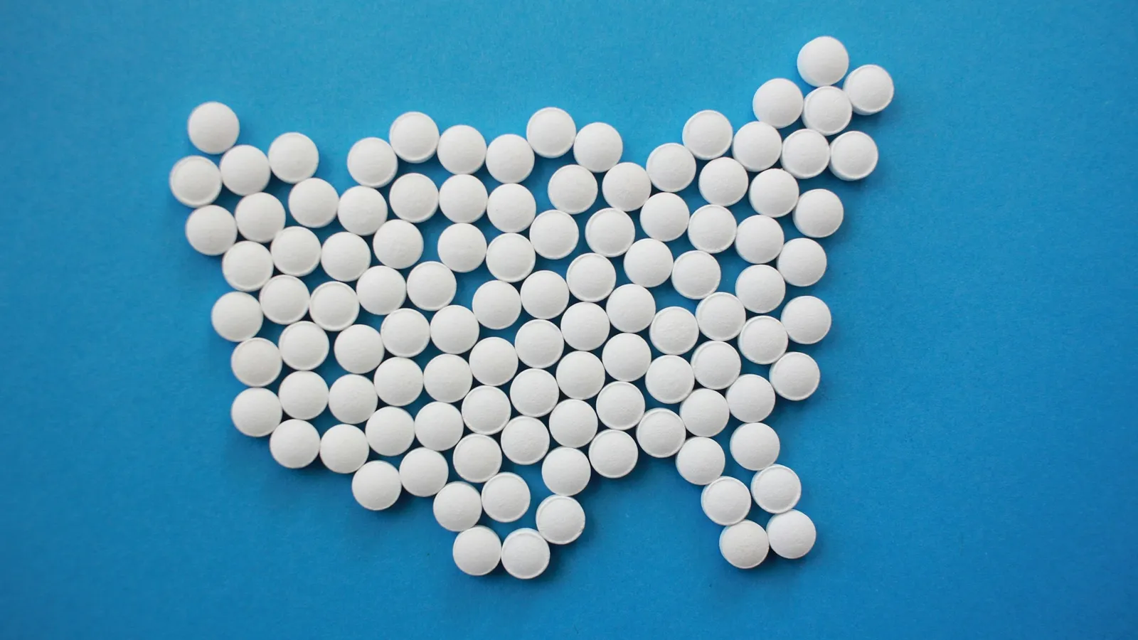 White tablets arranged on a blue background