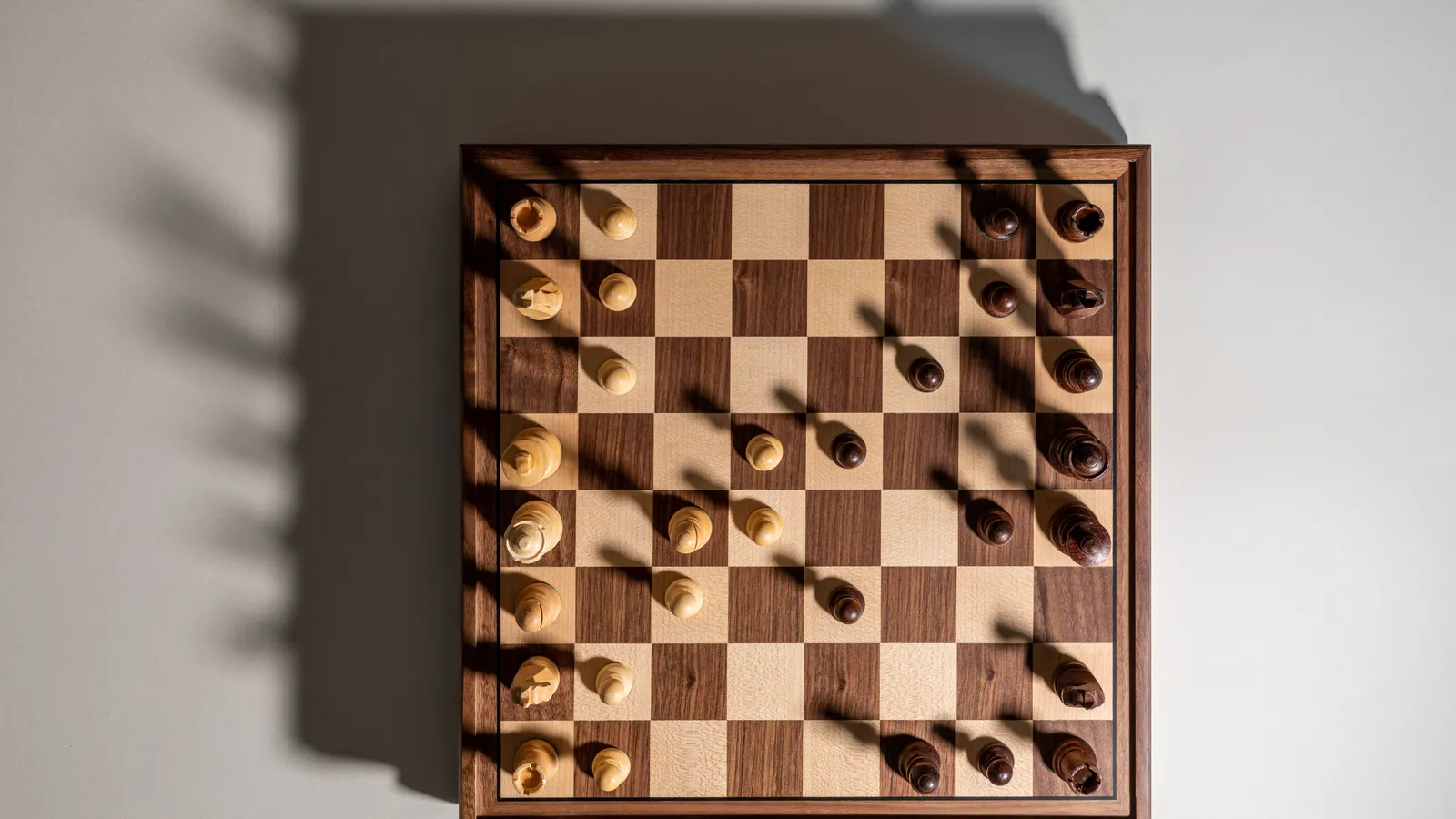 Wooden chessboard seen from above with a game in progress