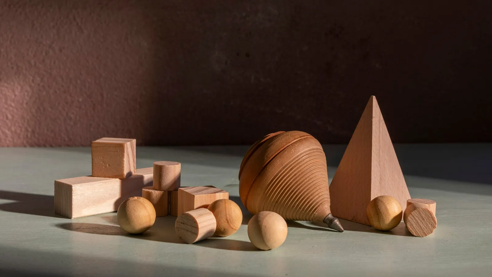 Wooden geometric solids including a cone, sphere and cylinder