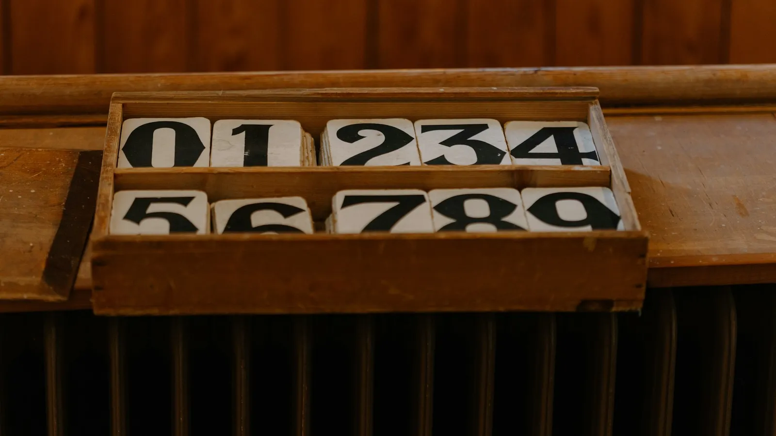 Wooden number tiles from 0 to 9 in a tray