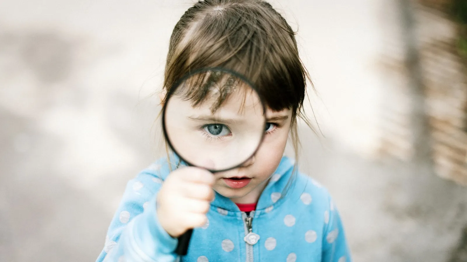 Young child looking through a magnifying glass