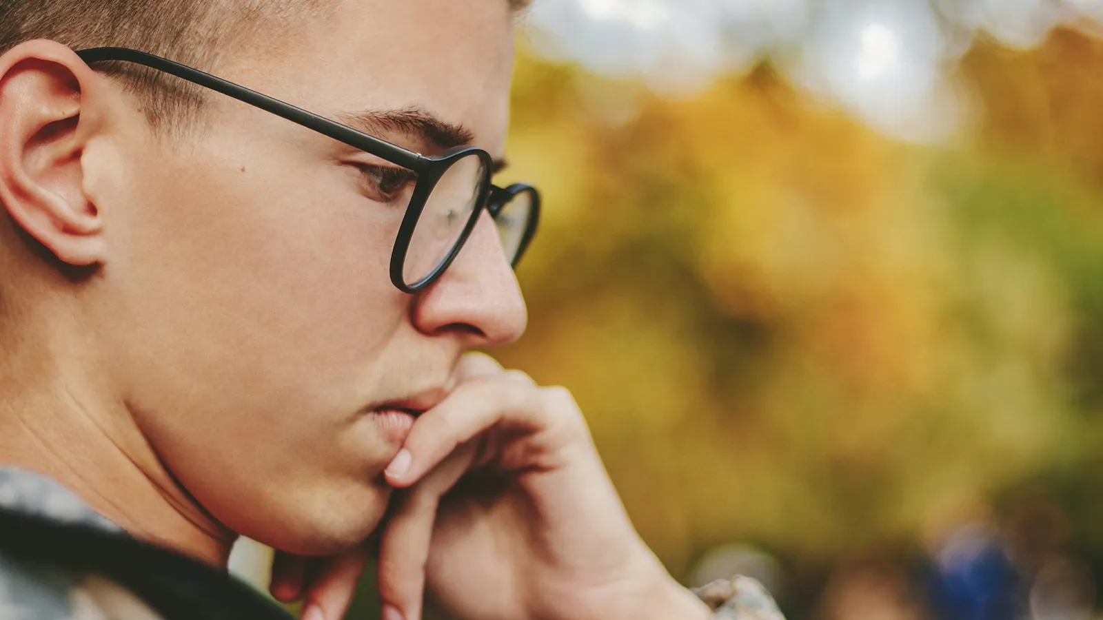 Young man in glasses deep in thought